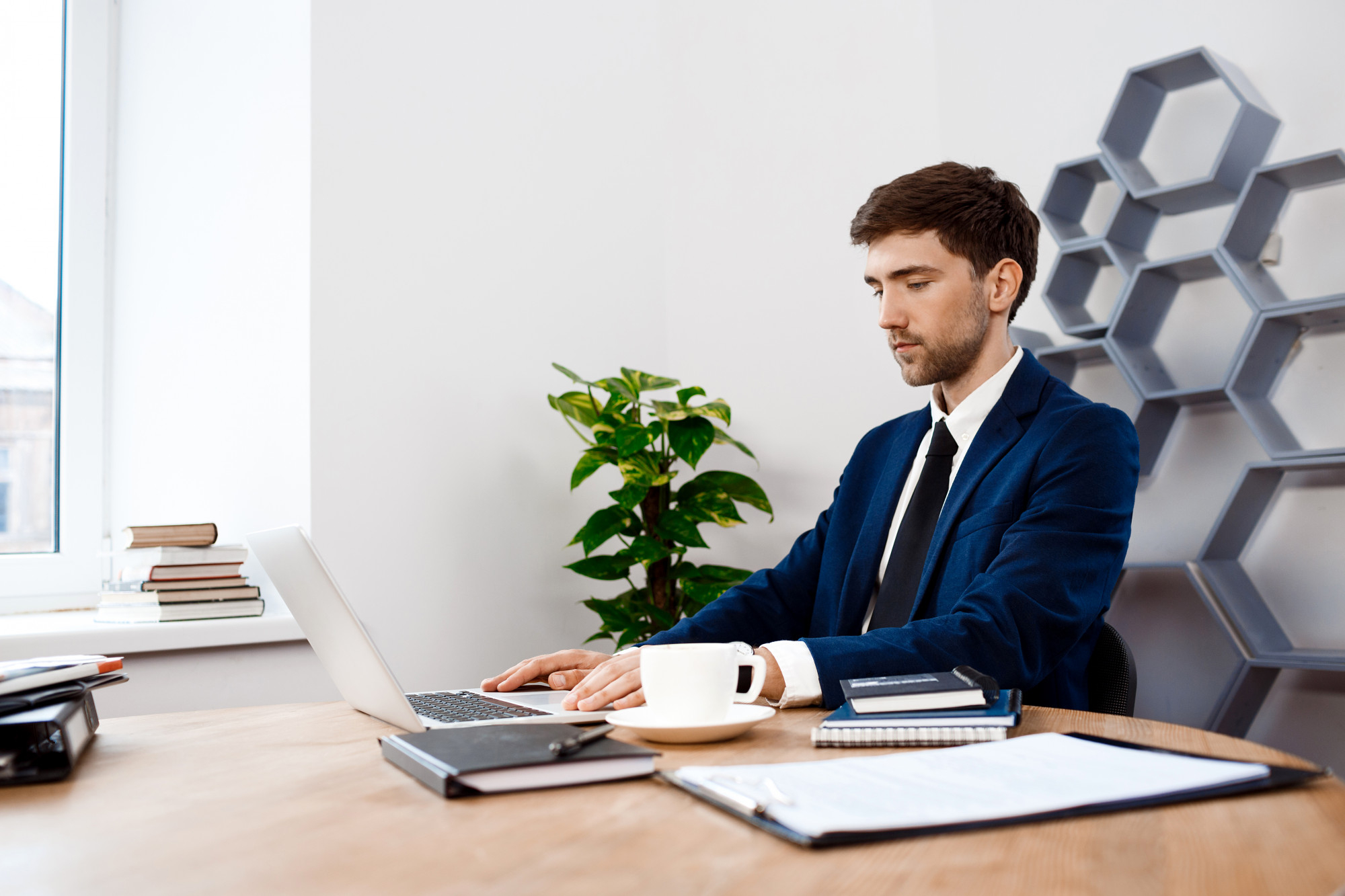 young-successful-businessman-sitting-laptop-office-background